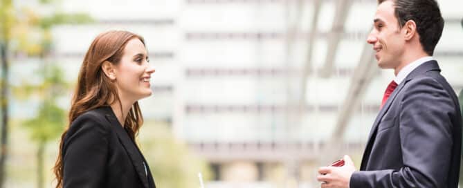 A franchise consultant giving advice to a business owner both wearing suits.