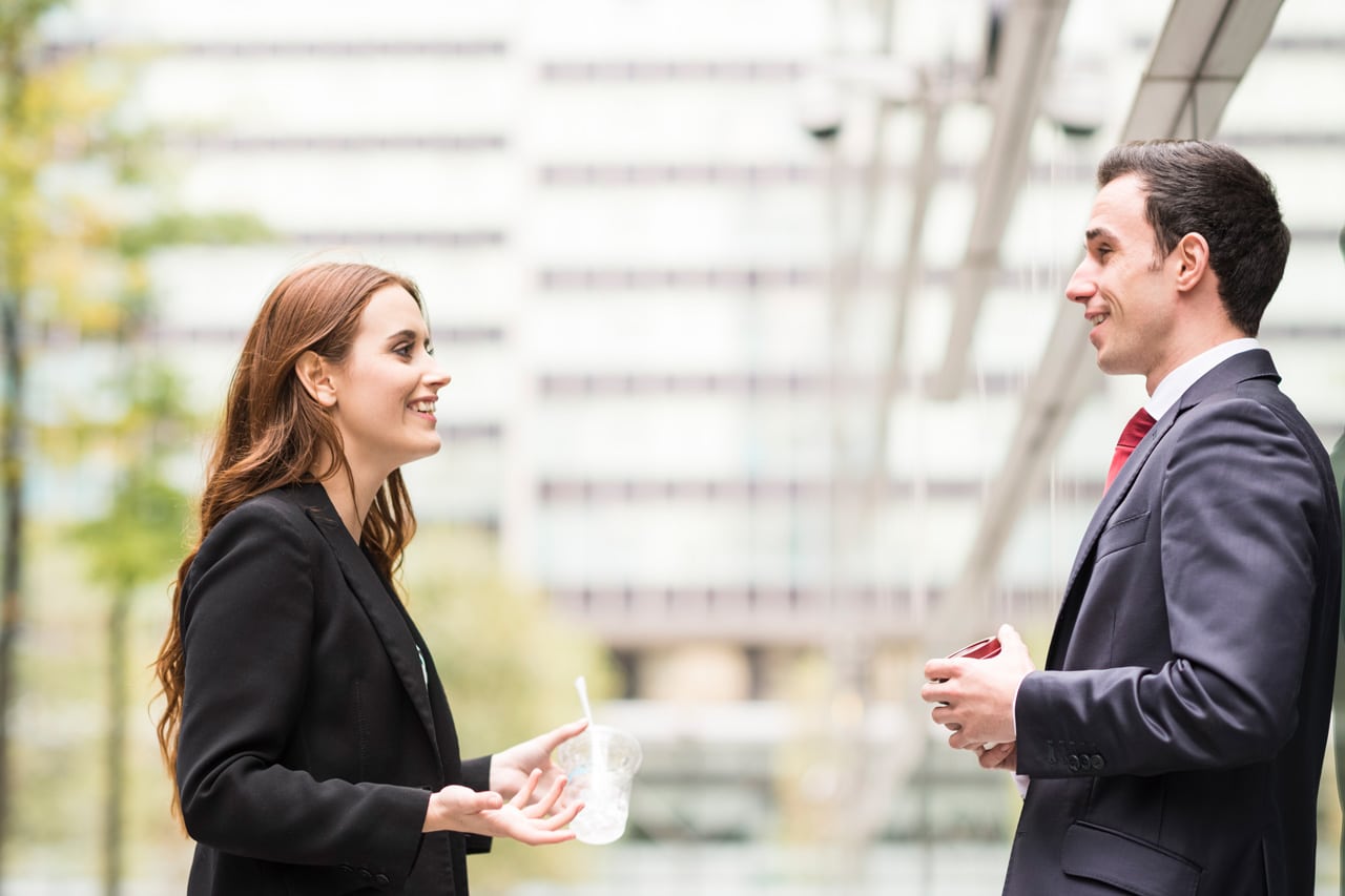 A franchise consultant giving advice to a business owner both wearing suits.
