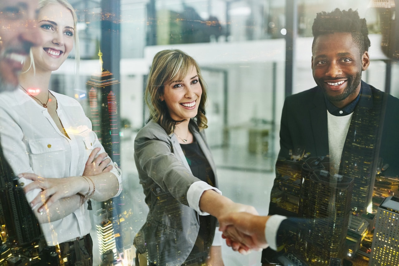 Franchise consultants shaking hands in a glass office